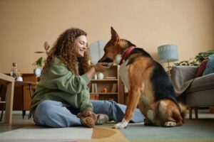 Happy Girl Giving medicine tablet To Pet Dog in Home Together